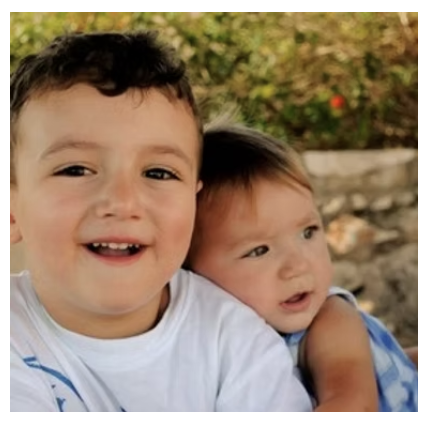 Two young children close together outdoors, illustrating early social development