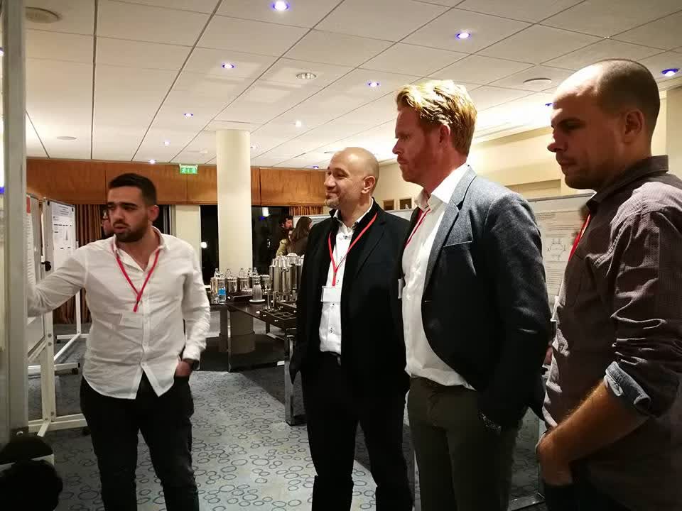 Discussions with international collaborators during a conference poster session.
